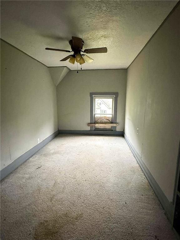 1202 Wall St, Galena, KS 66739 - empty room with carpet flooring, a ceiling fan, baseboards, a textured ceiling, and lofted ceiling