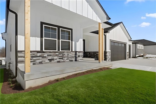 805 W Solomon Dr, Lone Jack, MO 64086 - view of side of property with board and batten siding, driveway, a lawn, and stone siding