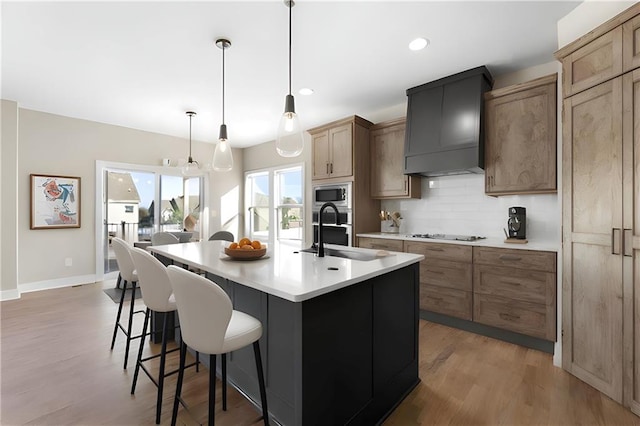 805 W Solomon Dr, Lone Jack, MO 64086 - kitchen featuring custom range hood, a sink, stainless steel microwave, tasteful backsplash, and a kitchen breakfast bar