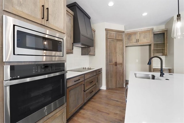 805 W Solomon Dr, Lone Jack, MO 64086 - kitchen featuring stainless steel appliances, a sink, custom range hood, light countertops, and light wood-style floors