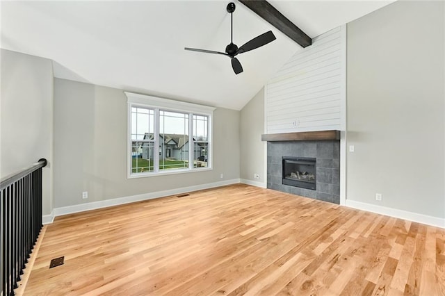 11207 207th St, Peculiar, MO 64078 - unfurnished living room with wood finished floors, a ceiling fan, a tile fireplace, and baseboards