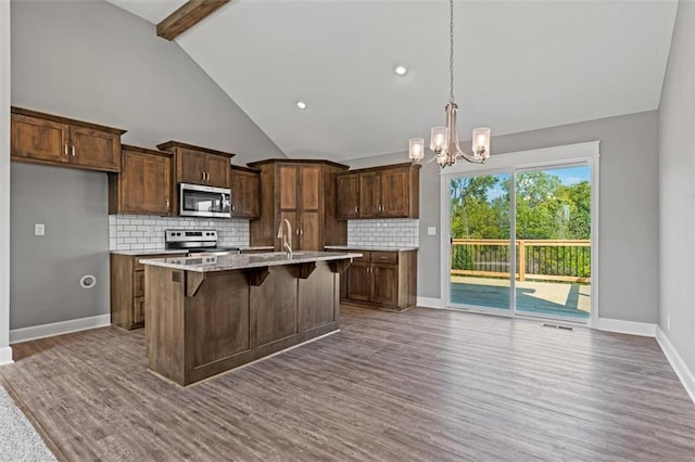 11207 207th St, Peculiar, MO 64078 - kitchen with appliances with stainless steel finishes, a chandelier, dark wood-type flooring, a sink, and backsplash