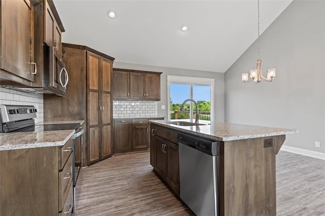 11207 207th St, Peculiar, MO 64078 - kitchen with stainless steel appliances, a sink, wood finished floors, a chandelier, and decorative backsplash