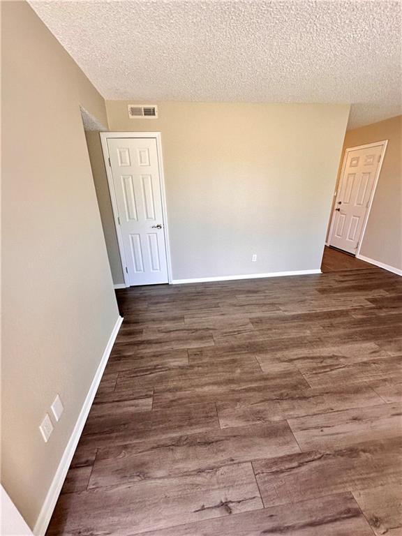 1710 Halsey Ave, Independence, KS 67301 - unfurnished room with dark wood-style floors, a textured ceiling, and baseboards
