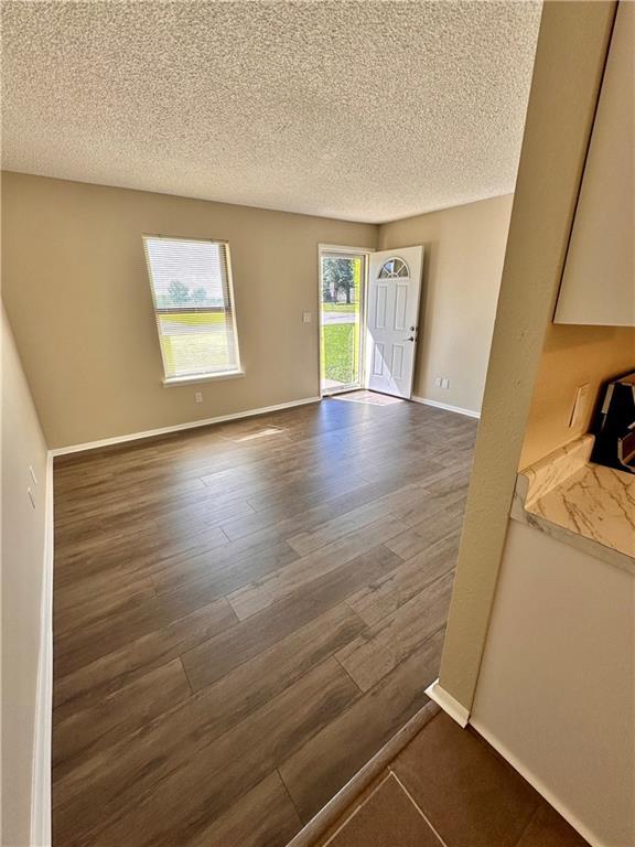 1710 Halsey Ave, Independence, KS 67301 - unfurnished room with dark wood finished floors, a textured ceiling, and baseboards