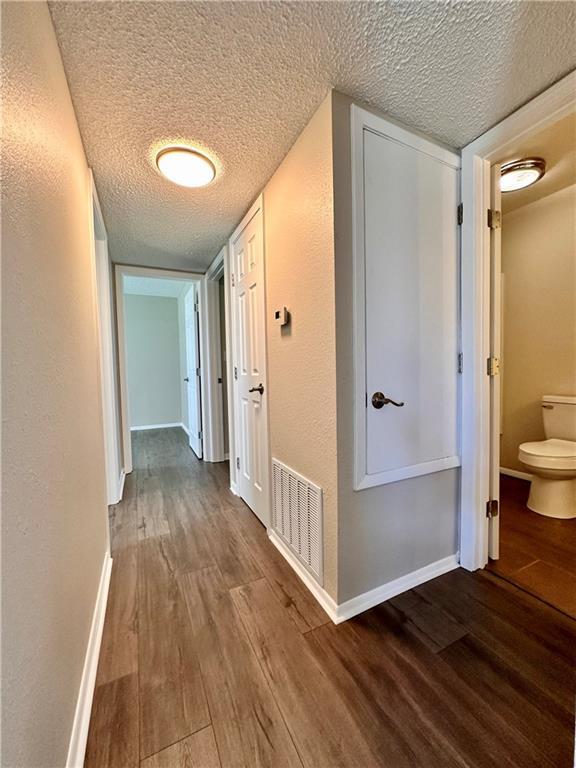 1710 Halsey Ave, Independence, KS 67301 - corridor with a textured ceiling, wood finished floors, and baseboards