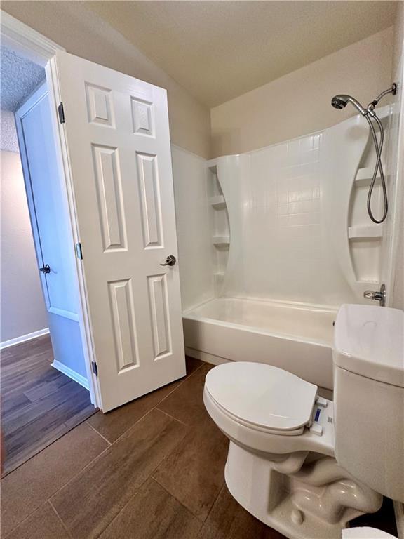 1710 Halsey Ave, Independence, KS 67301 - full bath featuring toilet, bathing tub / shower combination, tile patterned flooring, and baseboards
