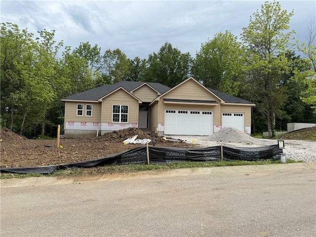 303 SW 17th St, Oak Grove, MO 64029 - view of front of home with a garage and view of wooded area