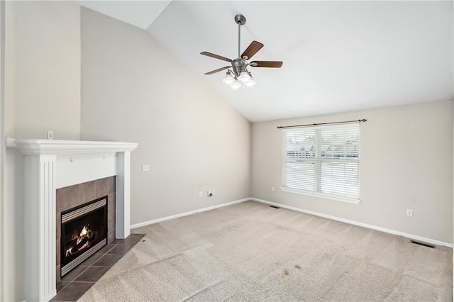 706 E 15th St E, Eudora, KS 66025 - unfurnished living room featuring lofted ceiling, carpet floors, ceiling fan, a tile fireplace, and baseboards