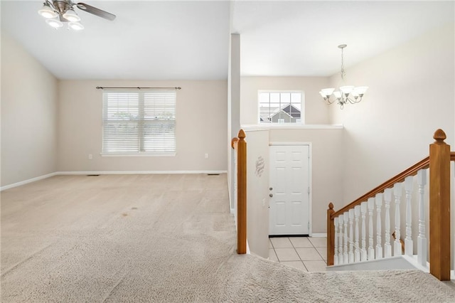 706 E 15th St E, Eudora, KS 66025 - carpeted entrance foyer featuring a chandelier, ceiling fan, baseboards, and tile patterned flooring