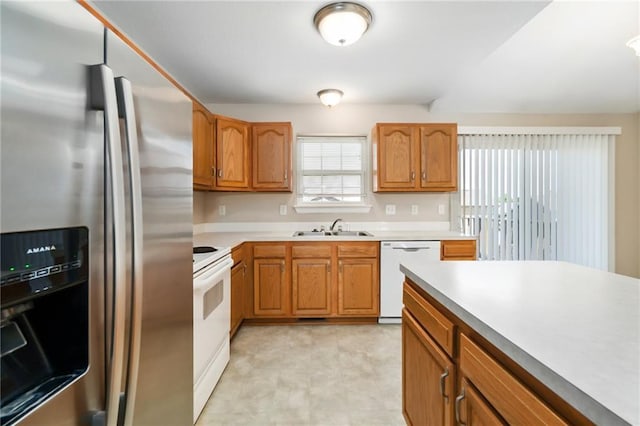706 E 15th St E, Eudora, KS 66025 - kitchen featuring white appliances, a sink, brown cabinetry, and light floors