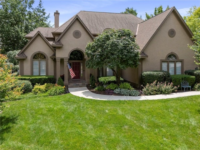 15141 Windsor Cir, Leawood, KS 66224 - view of front facade with stucco siding, a chimney, a front lawn, and roof with shingles