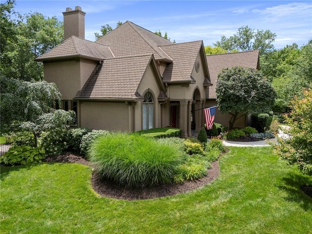 15141 Windsor Cir, Leawood, KS 66224 - view of front of home with stucco siding, a chimney, and a front lawn