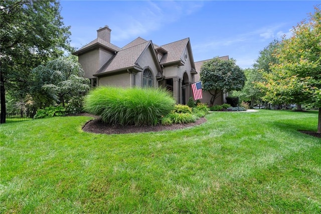 15141 Windsor Cir, Leawood, KS 66224 - view of side of property featuring stucco siding, a chimney, and a yard