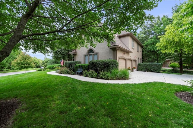 15141 Windsor Cir, Leawood, KS 66224 - view of side of home with stucco siding, a garage, concrete driveway, and a lawn