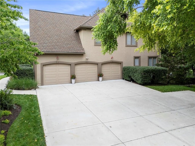 15141 Windsor Cir, Leawood, KS 66224 - view of front of property featuring stucco siding, driveway, and a garage
