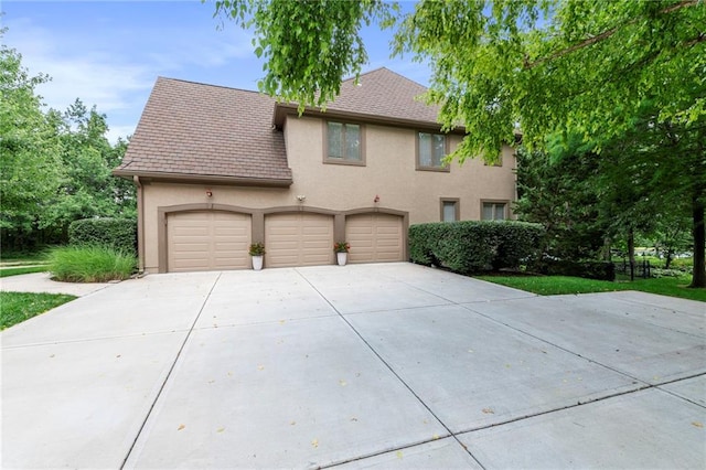 15141 Windsor Cir, Leawood, KS 66224 - view of front of home with concrete driveway, stucco siding, and a garage