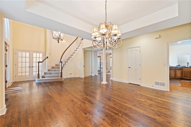 15141 Windsor Cir, Leawood, KS 66224 - unfurnished living room featuring a tray ceiling, a chandelier, and wood finished floors