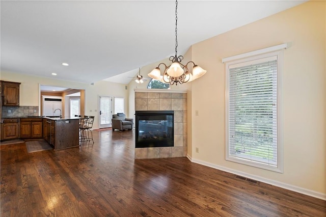 15141 Windsor Cir, Leawood, KS 66224 - living room with dark wood-type flooring, a tile fireplace, a chandelier, and recessed lighting