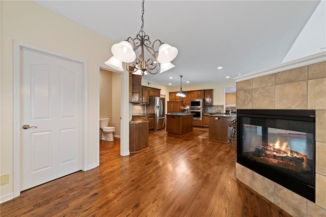 15141 Windsor Cir, Leawood, KS 66224 - kitchen featuring stainless steel appliances, a center island, recessed lighting, dark wood-type flooring, and a chandelier