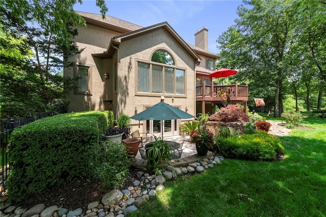 15141 Windsor Cir, Leawood, KS 66224 - rear view of property featuring stucco siding, a patio, a chimney, and a lawn