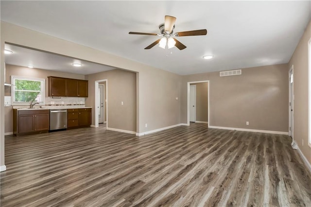 707 N Delaware St, Butler, MO 64730 - unfurnished living room with dark wood-type flooring, a ceiling fan, baseboards, and a sink