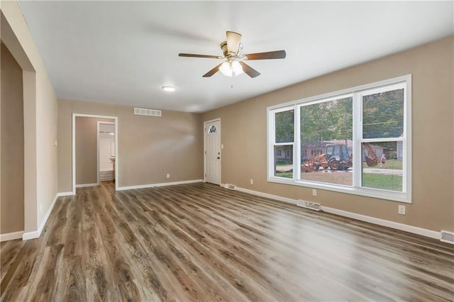 707 N Delaware St, Butler, MO 64730 - unfurnished living room featuring a ceiling fan, wood finished floors, and baseboards