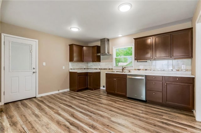 707 N Delaware St, Butler, MO 64730 - kitchen with stainless steel dishwasher, wall chimney range hood, light wood-style flooring, backsplash, and light countertops