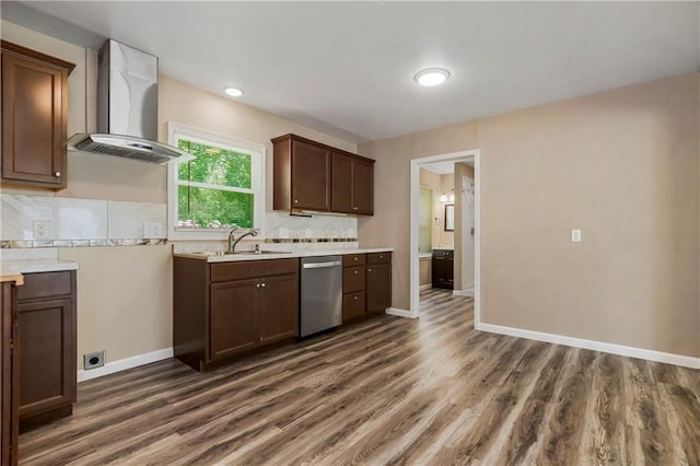 707 N Delaware St, Butler, MO 64730 - kitchen featuring wall chimney exhaust hood, stainless steel dishwasher, a sink, light countertops, and dark wood finished floors