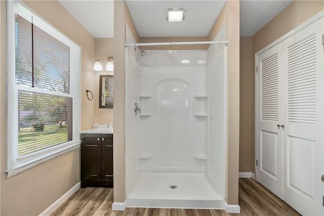 707 N Delaware St, Butler, MO 64730 - full bath featuring wood finished floors, vanity, a shower, and baseboards