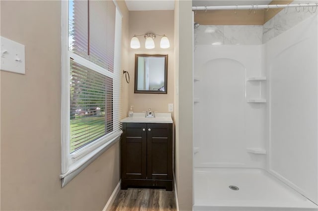 707 N Delaware St, Butler, MO 64730 - full bathroom with vanity, a shower, wood finished floors, and baseboards