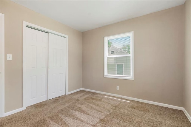 707 N Delaware St, Butler, MO 64730 - unfurnished bedroom with carpet flooring, baseboards, and a closet
