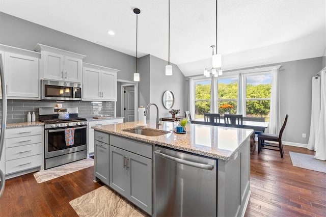 12930 N Champanel Way, Platte City, MO 64079 - kitchen with stainless steel appliances, a sink, tasteful backsplash, dark wood-style flooring, and a kitchen island with sink