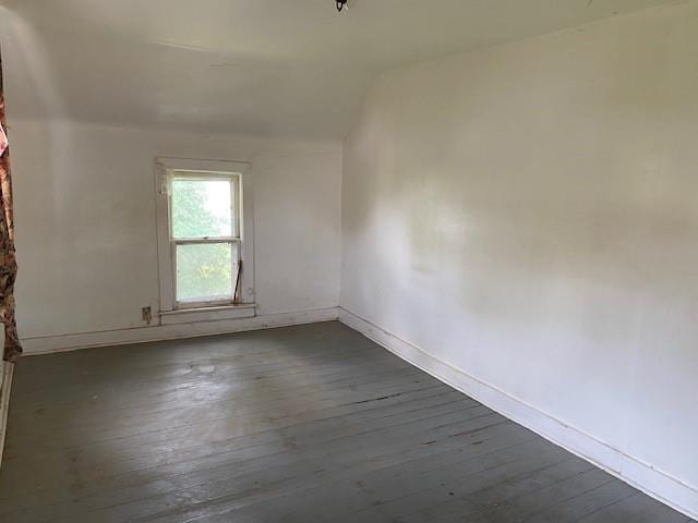 1209 S 6th St, Atchison, KS 66002 - empty room with dark wood-style floors, baseboards, and vaulted ceiling