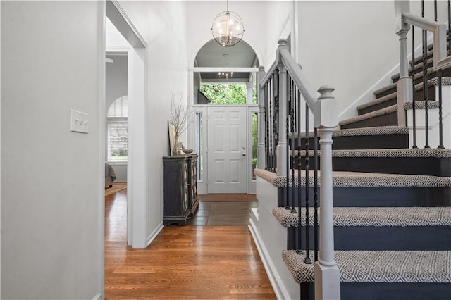 2705 W 137th Pl, Leawood, KS 66224 - foyer with wood finished floors, stairs, a chandelier, a towering ceiling, and baseboards