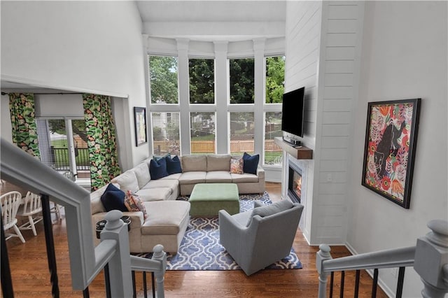 2705 W 137th Pl, Leawood, KS 66224 - living room with a large fireplace, wood finished floors, a towering ceiling, and baseboards