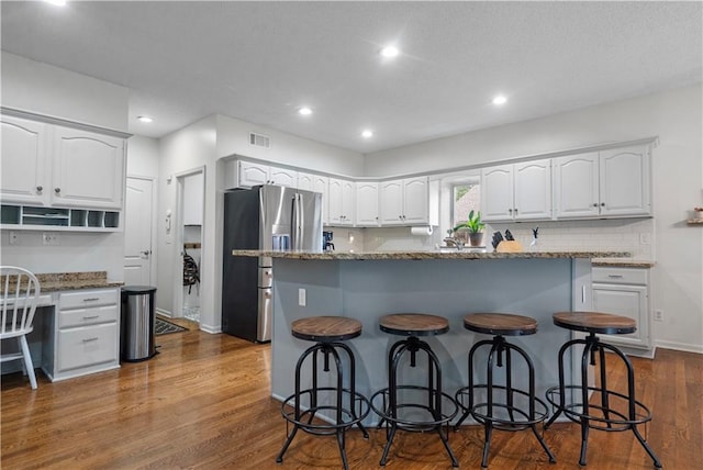 2705 W 137th Pl, Leawood, KS 66224 - kitchen with stainless steel fridge, a breakfast bar, white cabinets, and recessed lighting