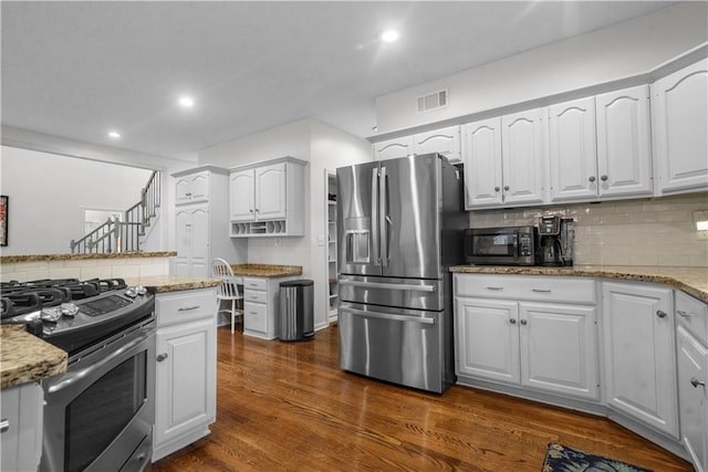 2705 W 137th Pl, Leawood, KS 66224 - kitchen with appliances with stainless steel finishes, backsplash, dark wood-style floors, light stone countertops, and white cabinets
