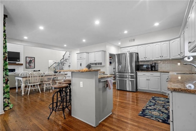 2705 W 137th Pl, Leawood, KS 66224 - kitchen featuring stainless steel refrigerator with ice dispenser, a breakfast bar area, a sink, stone counters, and white cabinetry