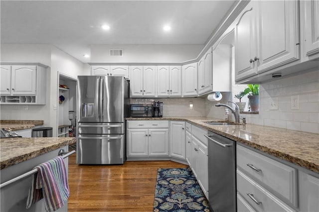 2705 W 137th Pl, Leawood, KS 66224 - kitchen with stainless steel appliances, a sink, light stone countertops, white cabinetry, and recessed lighting