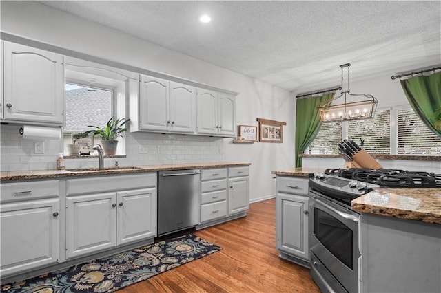 2705 W 137th Pl, Leawood, KS 66224 - kitchen featuring appliances with stainless steel finishes, a sink, tasteful backsplash, a textured ceiling, and recessed lighting