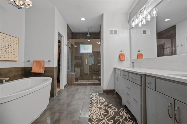 2705 W 137th Pl, Leawood, KS 66224 - bathroom with a shower stall, double vanity, a freestanding bath, recessed lighting, and a walk in closet