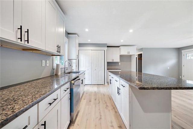508 N Geronimo Dr, Independence, MO 64056 - kitchen with light wood-style floors, a sink, white cabinets, dark stone countertops, and recessed lighting