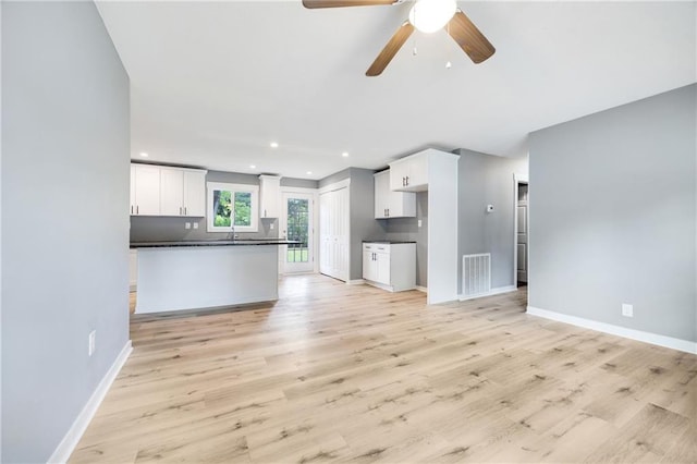 508 N Geronimo Dr, Independence, MO 64056 - unfurnished living room with baseboards, ceiling fan, light wood-type flooring, recessed lighting, and a sink