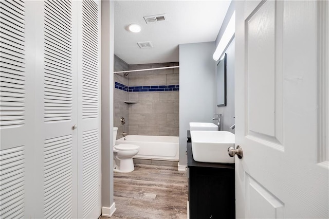 508 N Geronimo Dr, Independence, MO 64056 - bathroom featuring toilet, vanity, a closet, wood finished floors, and washtub / shower combination
