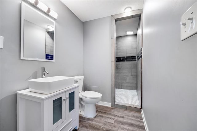 508 N Geronimo Dr, Independence, MO 64056 - full bathroom featuring toilet, a tile shower, wood finished floors, vanity, and baseboards