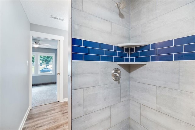 508 N Geronimo Dr, Independence, MO 64056 - full bathroom featuring tiled shower, wood finished floors, baseboards, and a ceiling fan