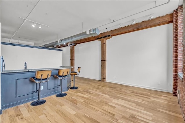 200 Main St Unit 211, Kansas City, MO 64105 - bar with track lighting, wood finished floors, baseboards, and a sink