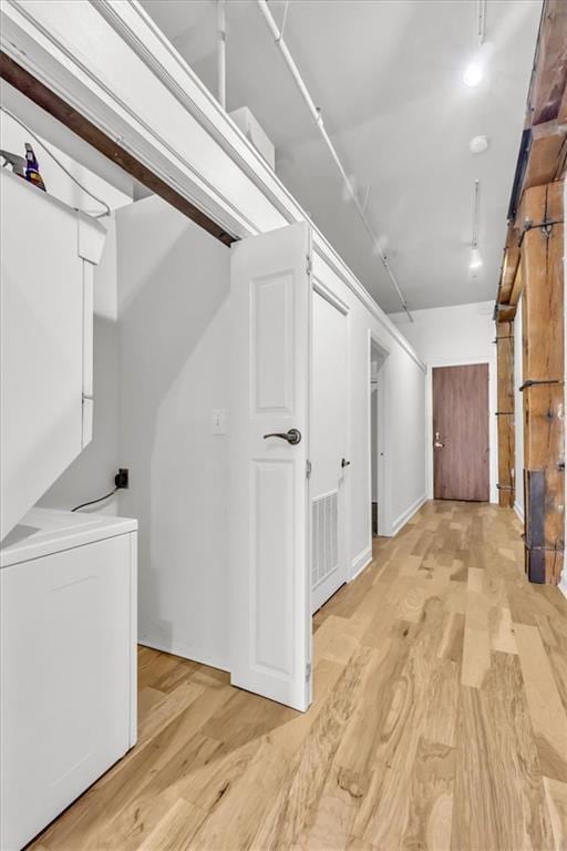 200 Main St Unit 211, Kansas City, MO 64105 - corridor featuring light wood-style flooring and stacked washing machine and dryer
