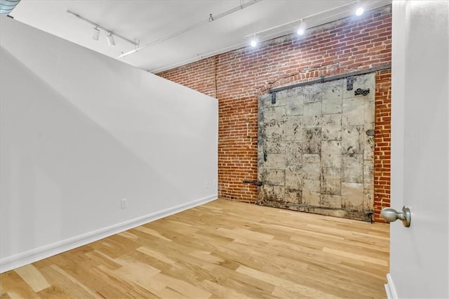 200 Main St Unit 211, Kansas City, MO 64105 - basement with rail lighting, brick wall, wood finished floors, and baseboards